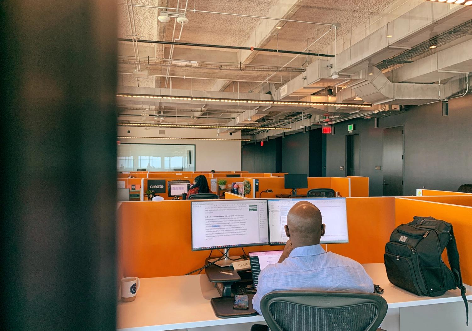 Man working in an orange office cube