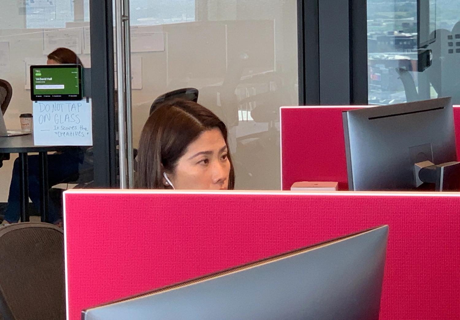 Woman working in a red office cube
