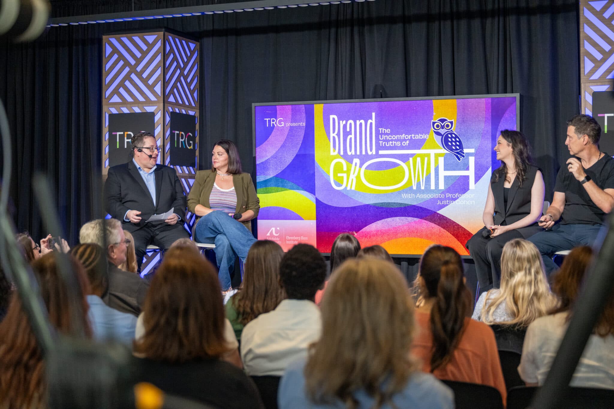 A four-person panel seated on stage during the “Brand Growth” discussion