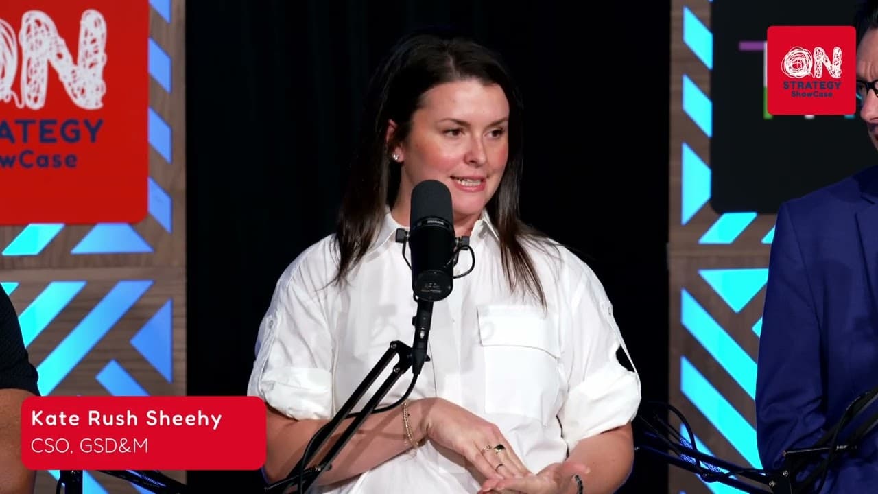 Kate Rush Sheehy, CSO of GSD&M, speaking into a microphone on the On Strategy Showcase set during the live Dallas recording